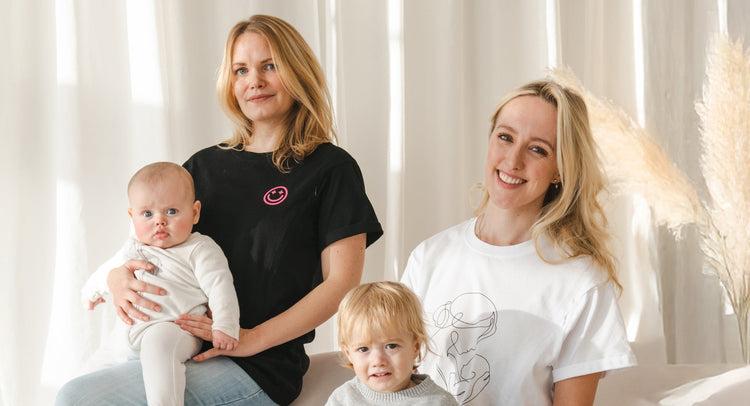 two women holding babies wearing milkmates t-shirts