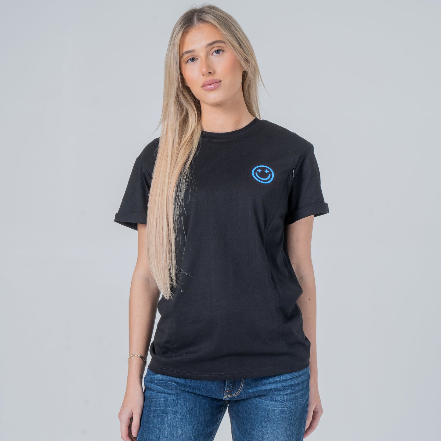 Woman wearing a black t-shirt with a blue smiley face logo on a gray background