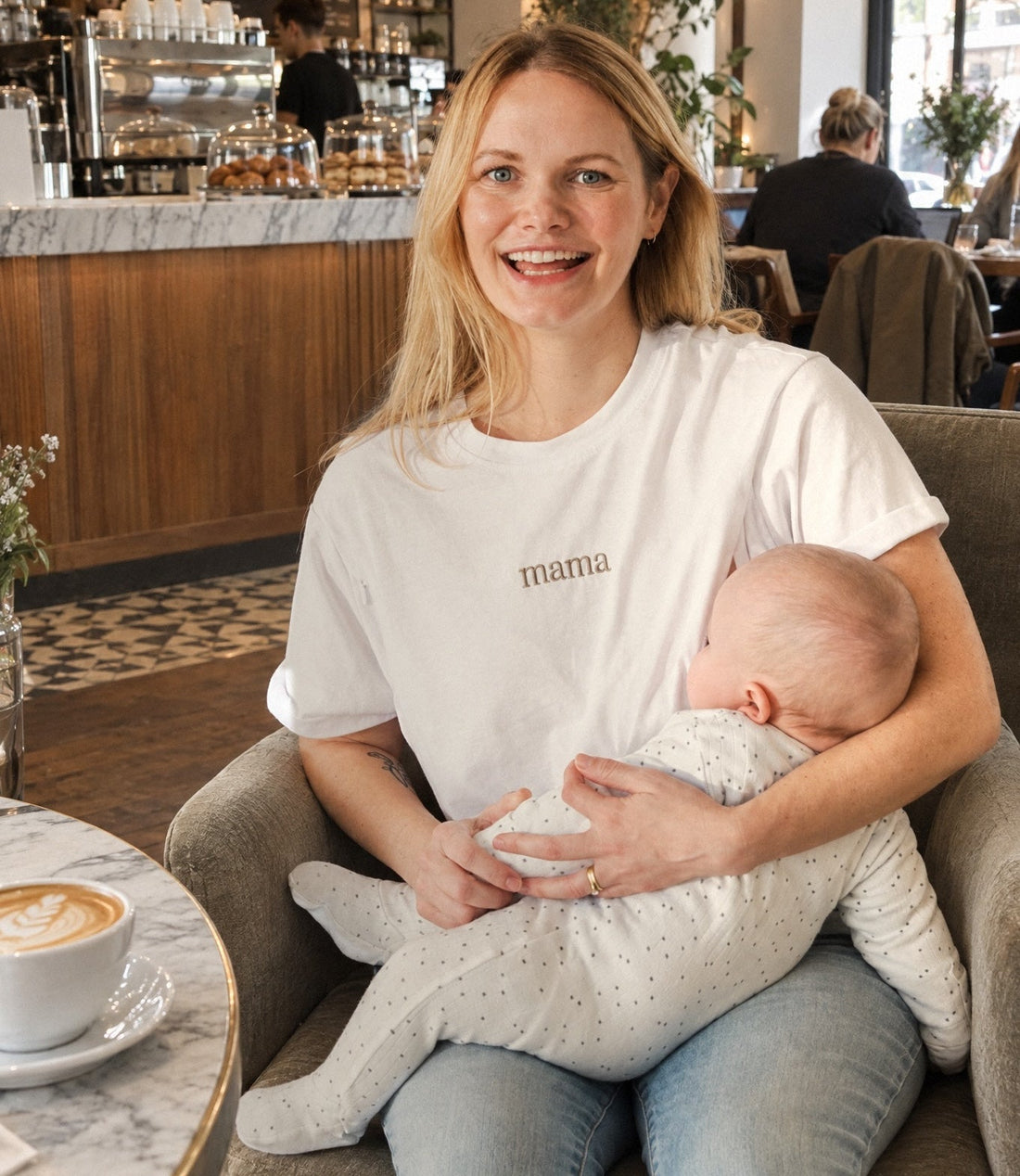 mom feeding baby at cafe in milkmates t-shirt