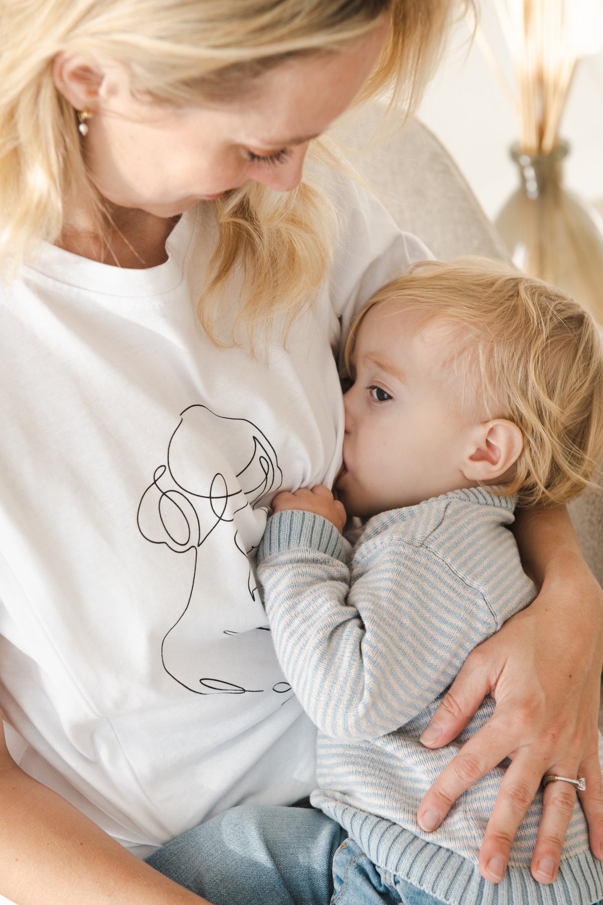 mom feeding baby in a milkmates t-shirt