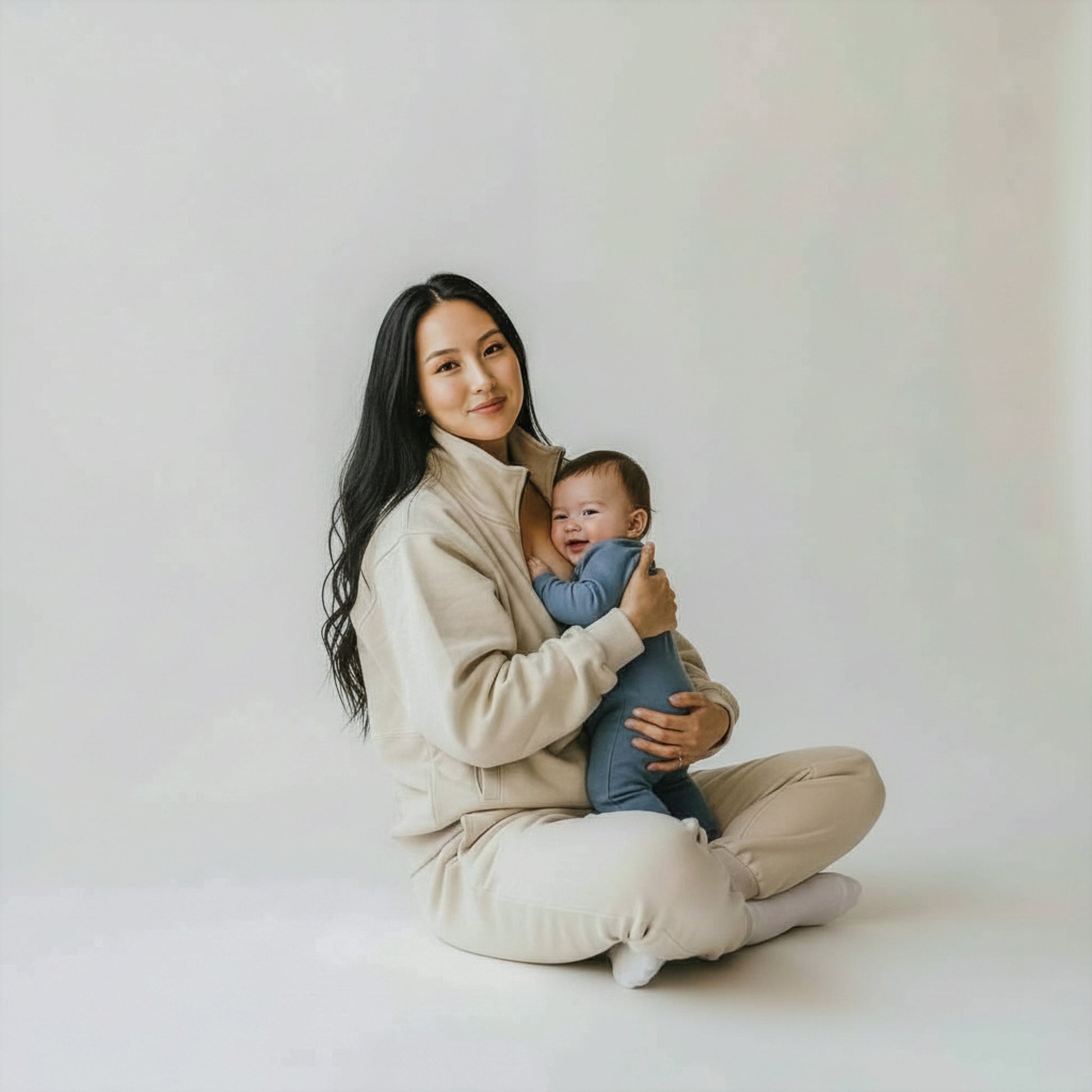 woman wearing beige milkmates nursing sweater and sweatpants set - with baby smiling